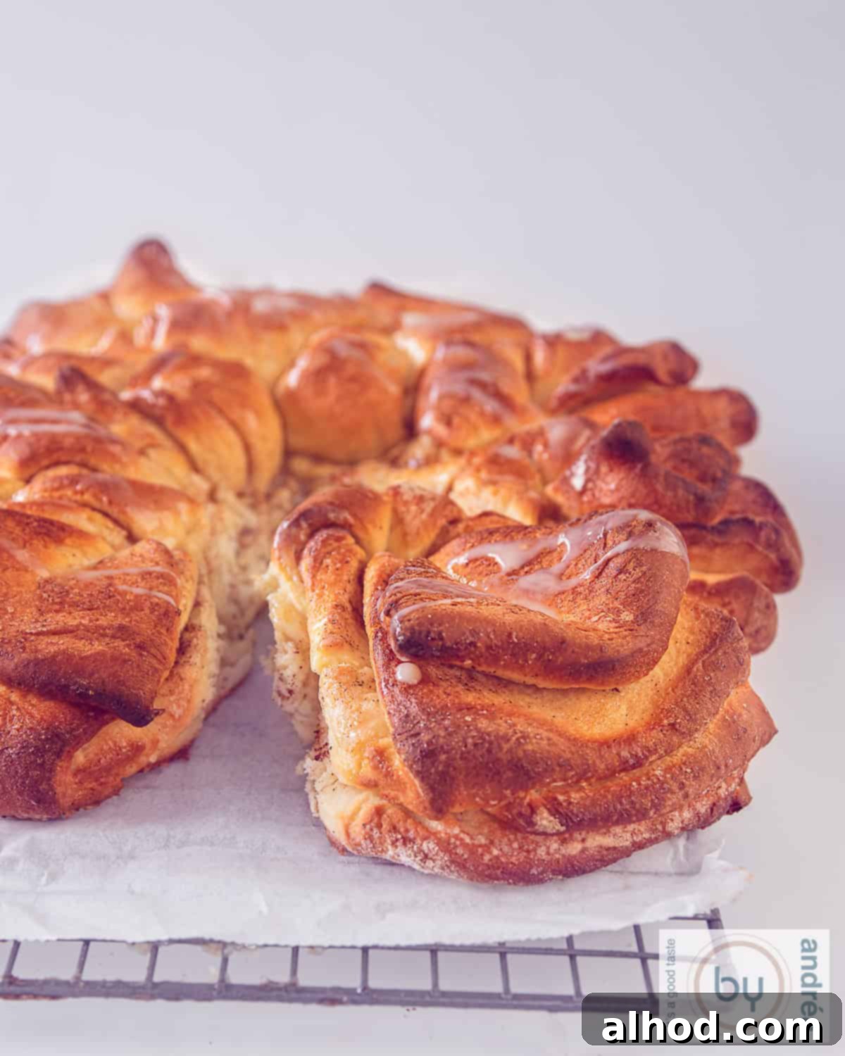 A high-angle picture of a star cinnamon bread drizzled with condensed milk. A slice cut off.
