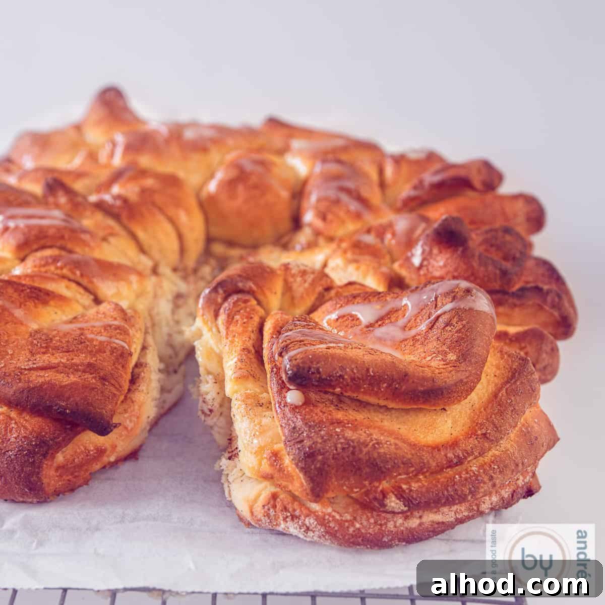 A square picture of part of a cinnamon star bread layered, with condensed mik drizzled on top.