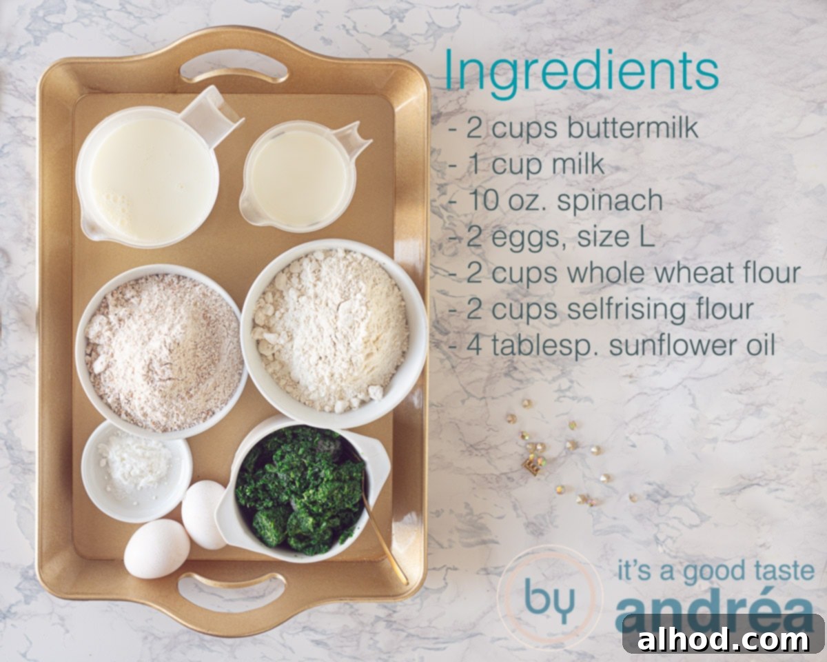 A flat lay photograph showcasing the key ingredients for making whole wheat spinach pancakes, including fresh spinach, various flours, eggs, milk, and buttermilk arranged neatly on a surface.