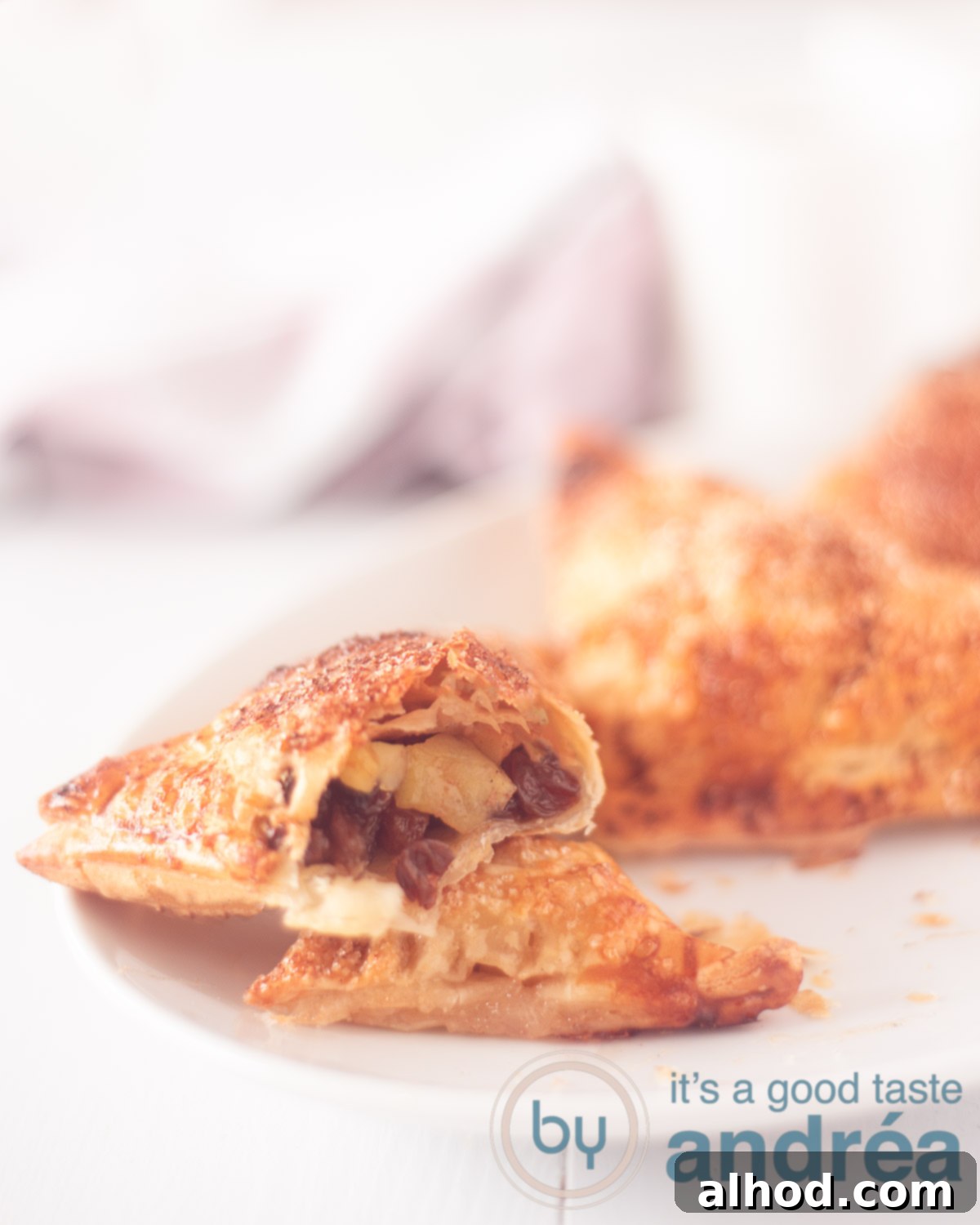 Classic Dutch Apple Turnovers 5 Close-up photo of a perfectly baked appelflap, showcasing its golden-brown, crispy puff pastry and a hint of the sweet apple filling.
