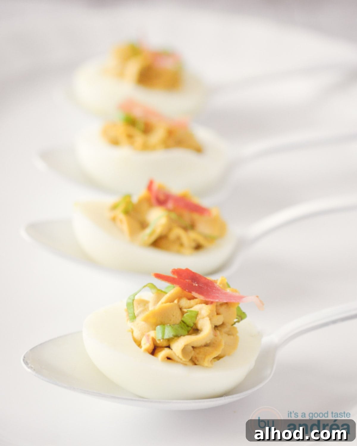 Italian Pancetta Balsamic Deviled Eggs 2 Gourmet Italian deviled eggs with crispy pancetta and balsamic glaze on white spoons