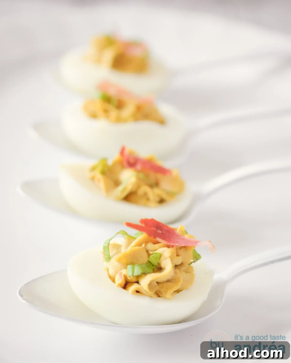 Italian-Style Deviled Eggs with Pancetta and Balsamic Glaze 3 Italian flavored deviled eggs with pancetta and balsamic on 4 white spoons