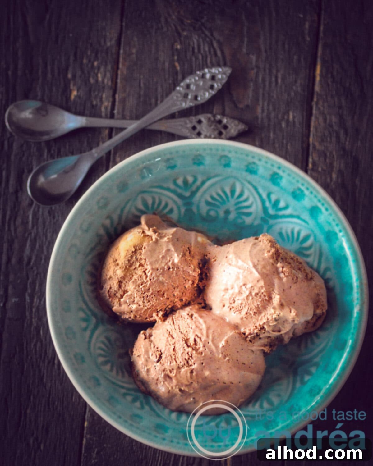 Decadent No-Machine Chocolate Ice Cream 7 two silver spoons, a blue bowl with three scoops of chocolate ice cream