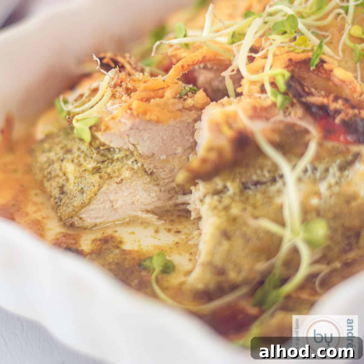 Golden Pesto Chicken with Sundried Tomatoes and Melty Mozzarella 4 A square photo of a white baking dish, portion, chicken fillet with pesto and cheese