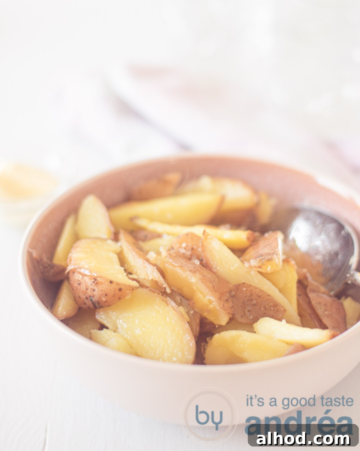 Crispy Oven Fries 5 A pink bowl with fries and a silver spoon on a white background.