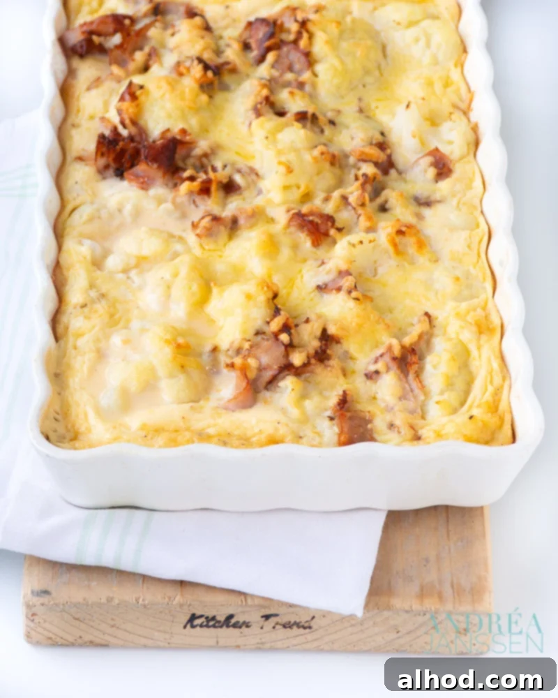 Bacon Cauliflower Gratin 2 Delicious baked cauliflower bacon gratin in a casserole dish, topped with golden-brown cheese.