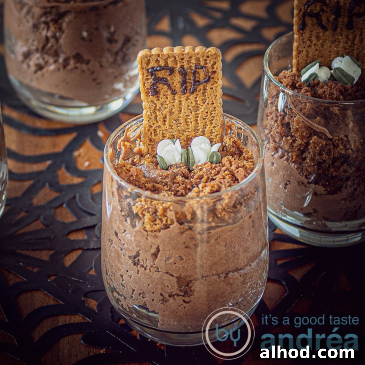 Easy Chocolate Graveyard Mousse 4 A square photo of a chocolate mousse dessert with a tombstone, RIP and flowers in a dark background