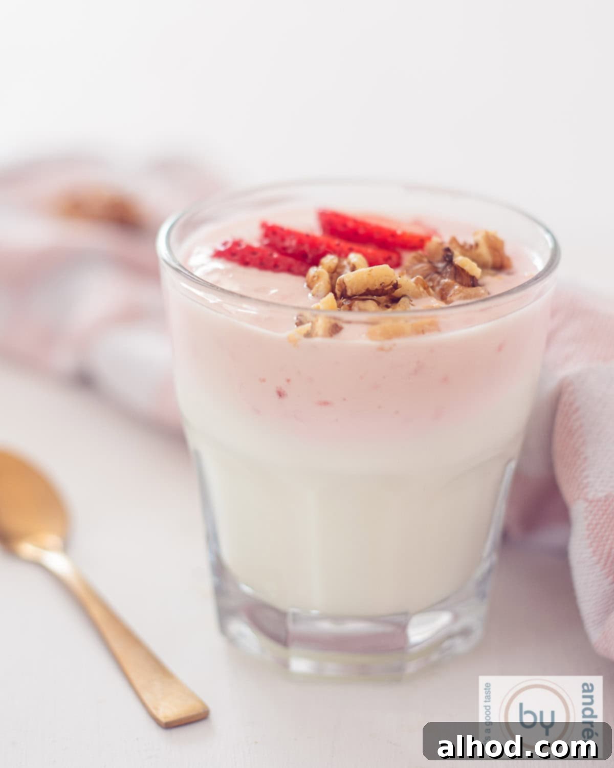 Effortless Strawberry Yogurt Parfait 3 A height photo showing a glass of strawberry yogurt with fresh strawberries and walnuts.