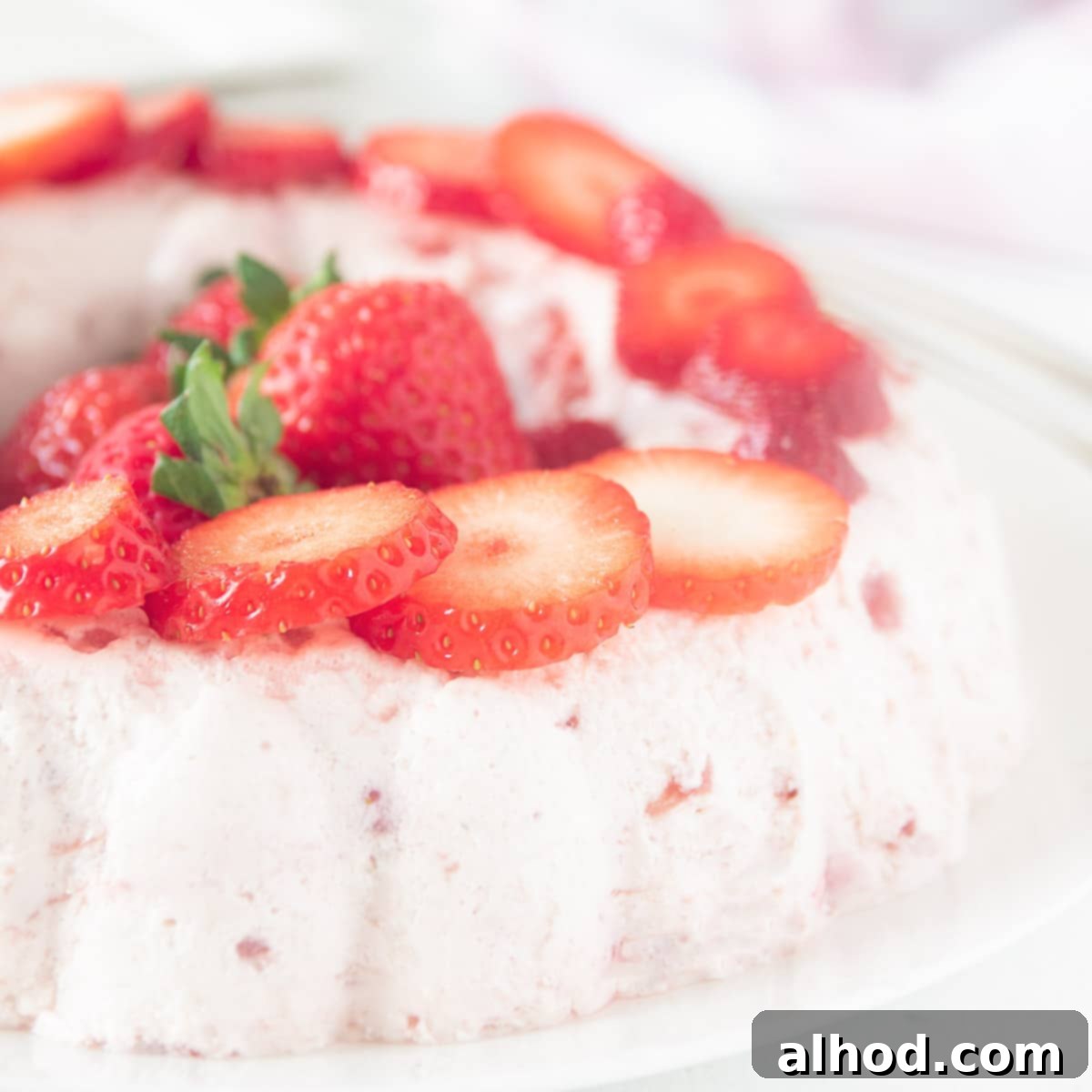 Luscious Strawberry Bavarois 6 A square photo with part of a bavarian with strawberries garnished with strawberry slices