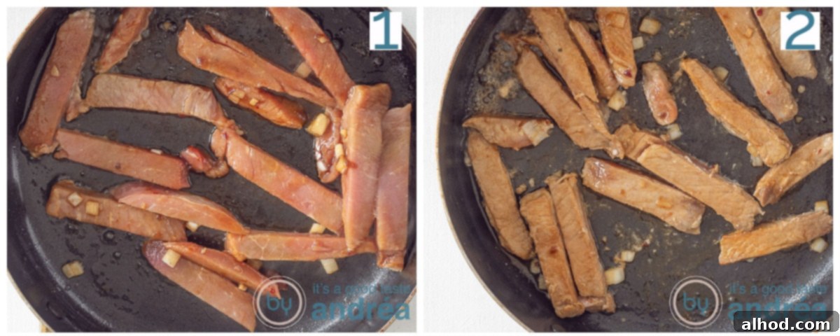 Authentic Chinese Babi Pangang Recipe 5 A close-up of pork strips frying in a skillet with onions.