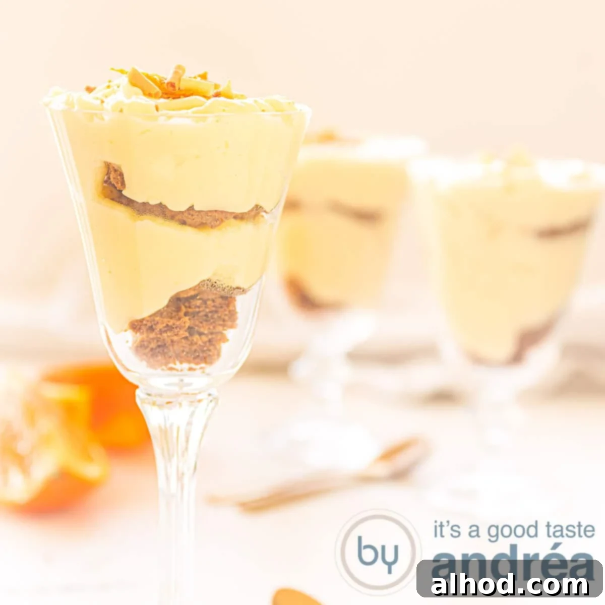 Zesty Orange Delight 5 A square photo with three glasses filled with orange and bastogne custard. An orange white background