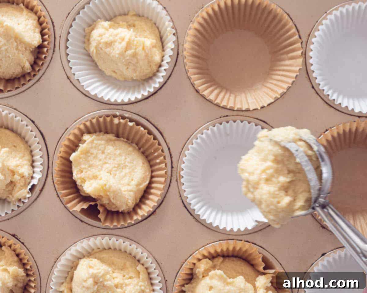 Effortless Salted Caramel Cupcake Delights 6 A muffin tin with paper cups. Batter is added to the cups with an ice cream scoop