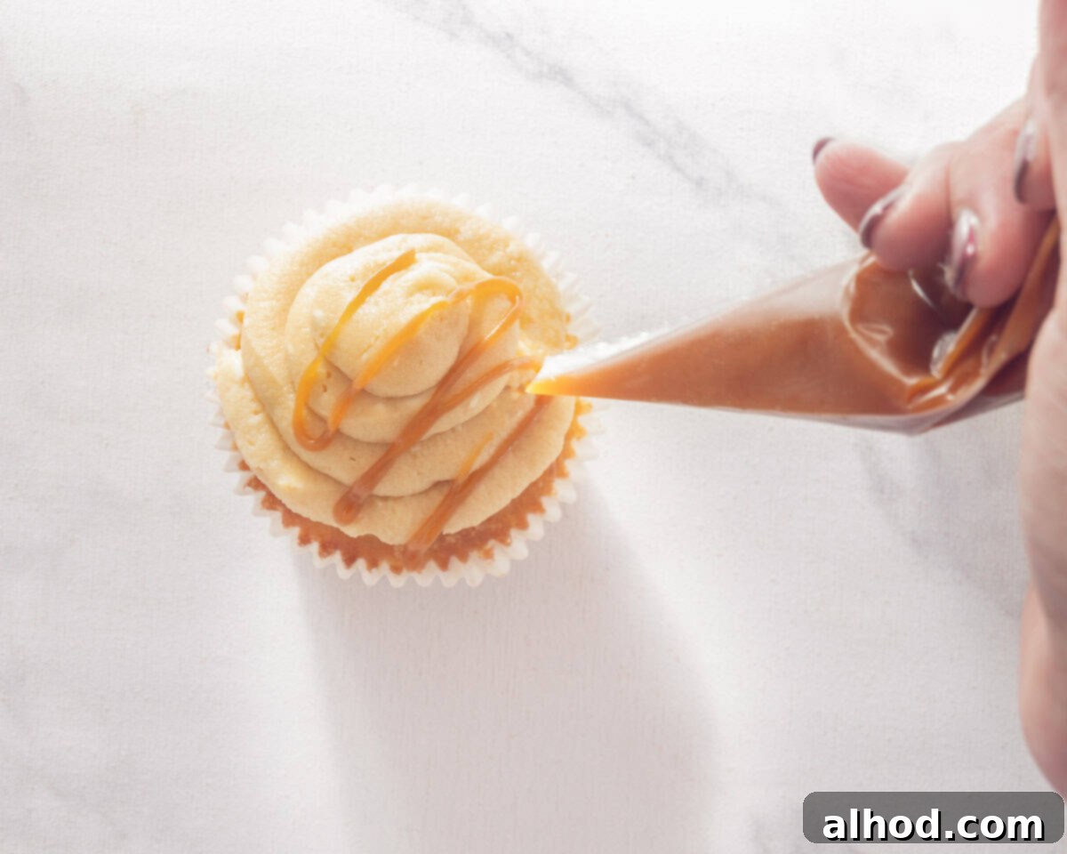 Effortless Salted Caramel Cupcake Delights 8 A piping bag piping salted caramel to the top of the cupcakes