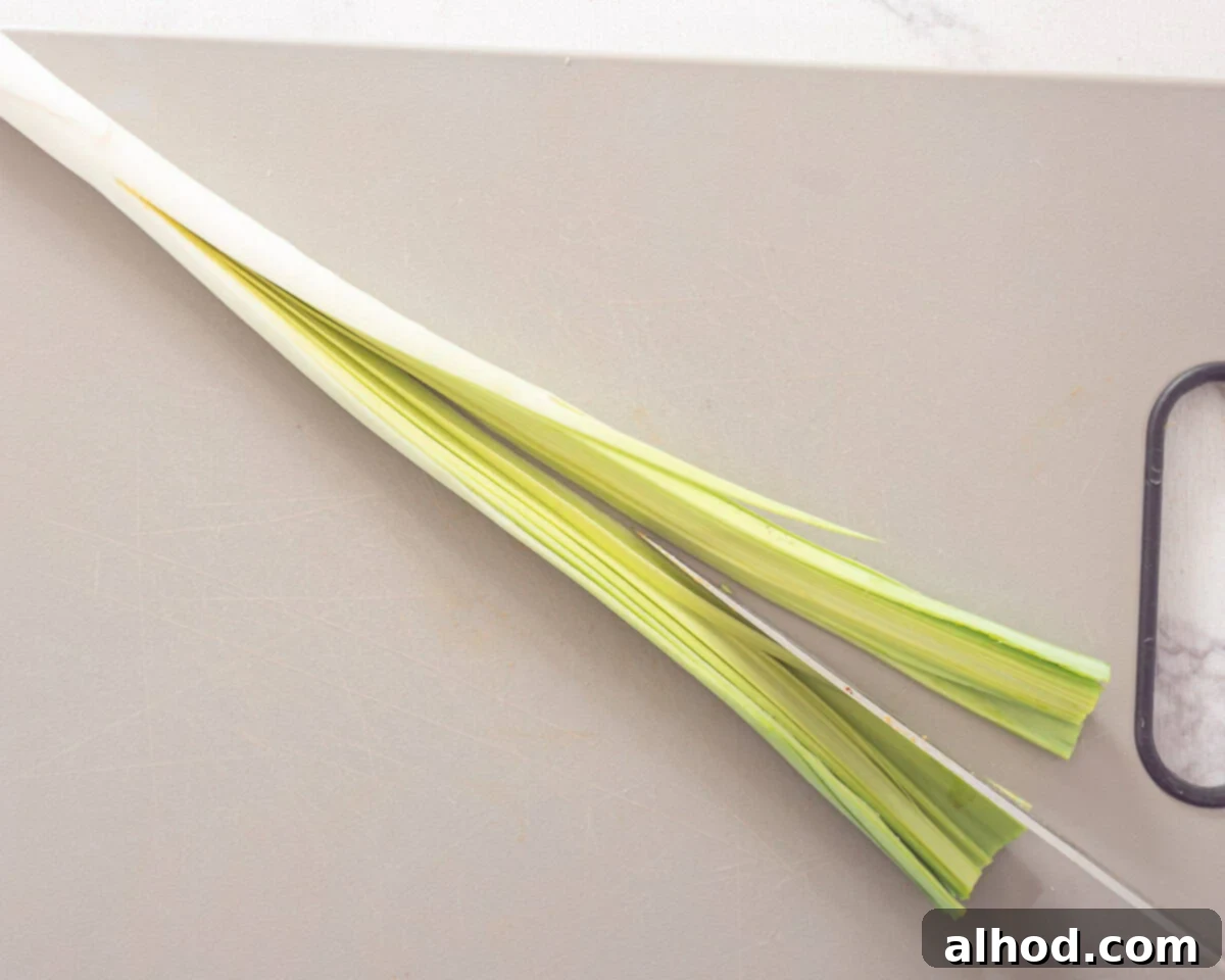 Effortless Leek Prep 4 A knife slicing a leek lengthwise, starting near the root