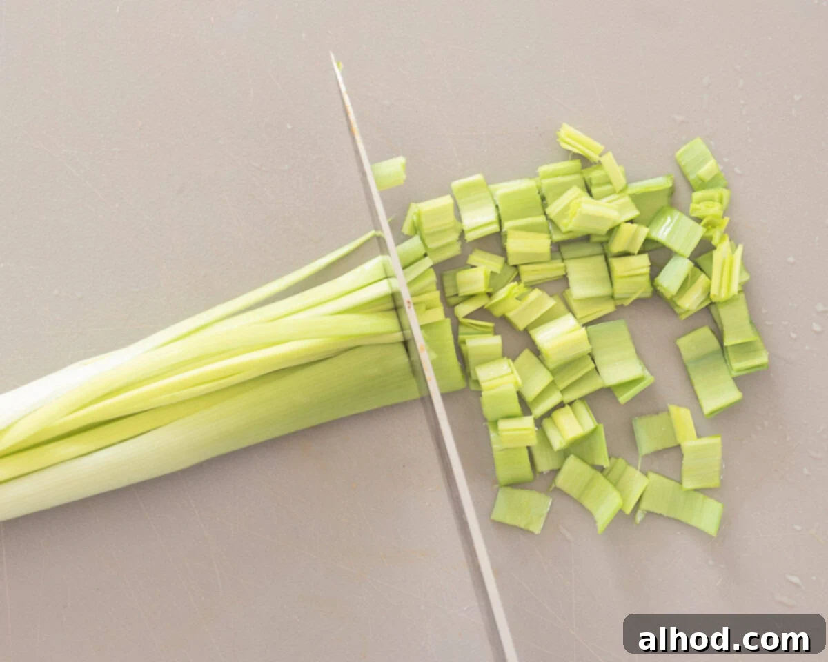 Effortless Leek Prep 6 Hands holding a quartered leek under running water, fanning out the layers