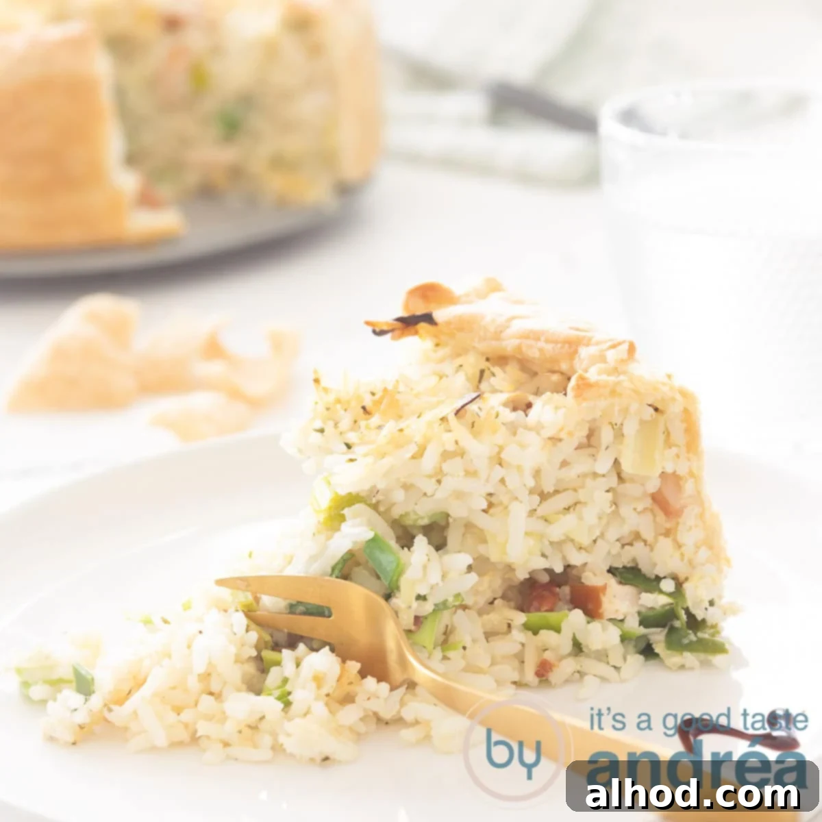 Golden Chicken Leek Rice Quiche 5 A square photo with a quiche point filled with smoked chicken, leek and rice. In the background the rest of the savory pie