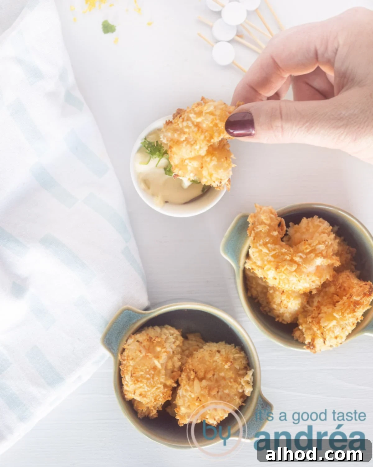 Crispy Garlic Shrimp Bites with Tangy Lemon Aioli 2 A top photo of two bowls of crispy garlic shrimp. A hand dipping a piece of shrimp into the creamy lemon aioli dip.
