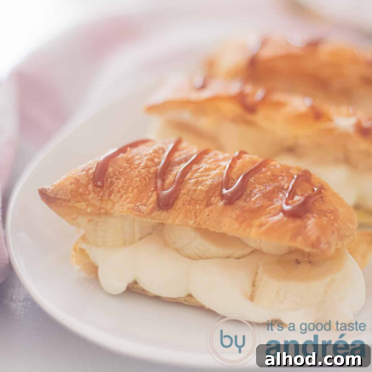 Caramelized Banana Mille-Feuille 6 A square photo with three napoleons in a row filled with whipped cream and with caramel sauce