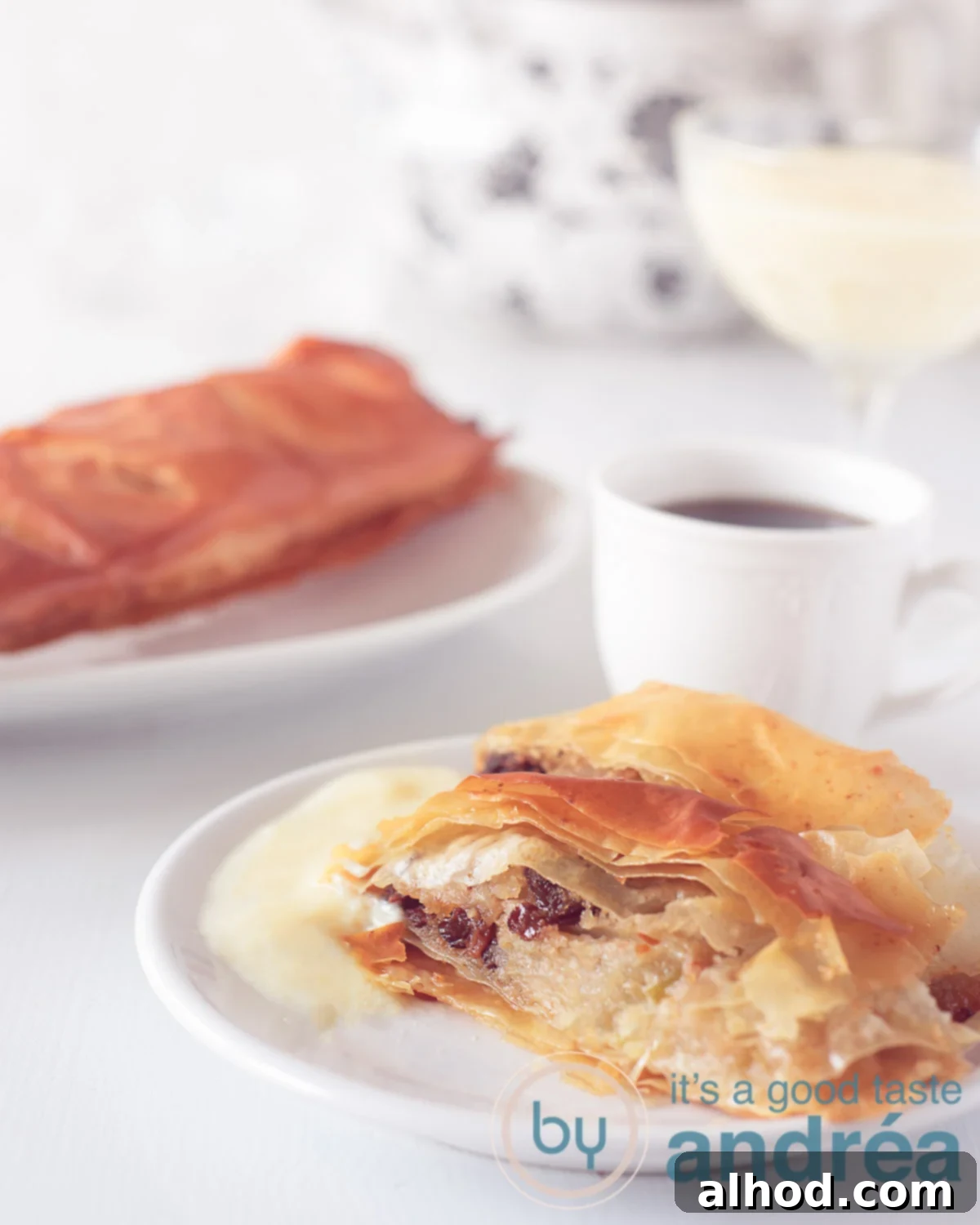 Authentic German Apple Strudel 6 A close-up photo of a golden-brown baked apple strudel (Apfelstrudel), showing its crispy layers and tempting apple filling, ready to be enjoyed.