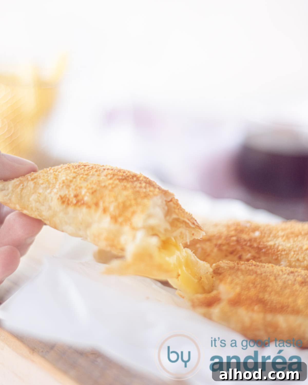 Air Fryer Kaassoufflé Crispy Cheese Puffs 2 A golden-brown Dutch Kaassoufflé, freshly cut open, revealing its rich, melted cheese filling. The cheese is stretchy and inviting.