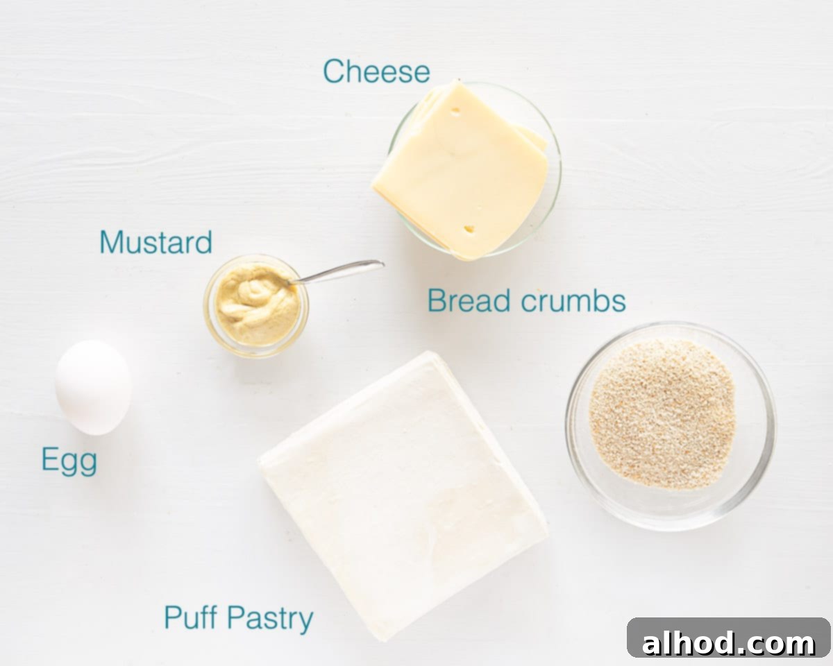 Air Fryer Kaassoufflé Crispy Cheese Puffs 3 A collection of ingredients for making Kaassoufflé: puff pastry, raclette cheese, mustard, an egg, and breadcrumbs, arranged on a white cutting board.