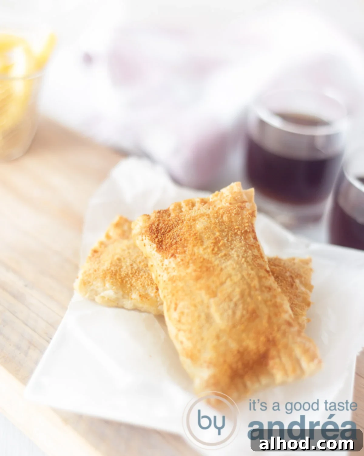 Air Fryer Kaassoufflé Crispy Cheese Puffs 6 Two homemade cheese snacks on a white baking paper on a wooden board.