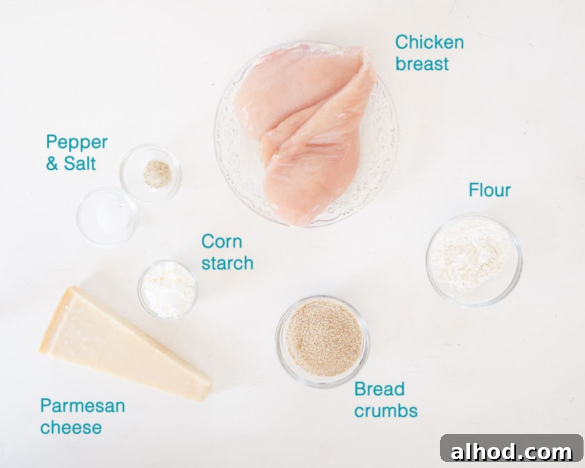 Parmesan Crusted Chicken Nuggets 3 Individual ingredients for Parmesan Chicken Nuggets, including chicken breast, flour, cornstarch, breadcrumbs, Parmesan cheese, and sunflower oil, arranged on a white background.