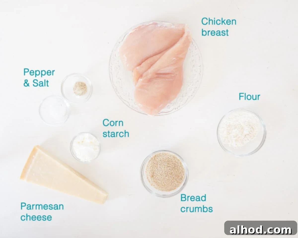 Crispy Parmesan Chicken Bites 3 A vibrant flat lay image showcasing all the fresh ingredients needed for Parmesan Chicken Nuggets, including chicken breast, flour, cornstarch, breadcrumbs, grated Parmesan cheese, and a bottle of sunflower oil.