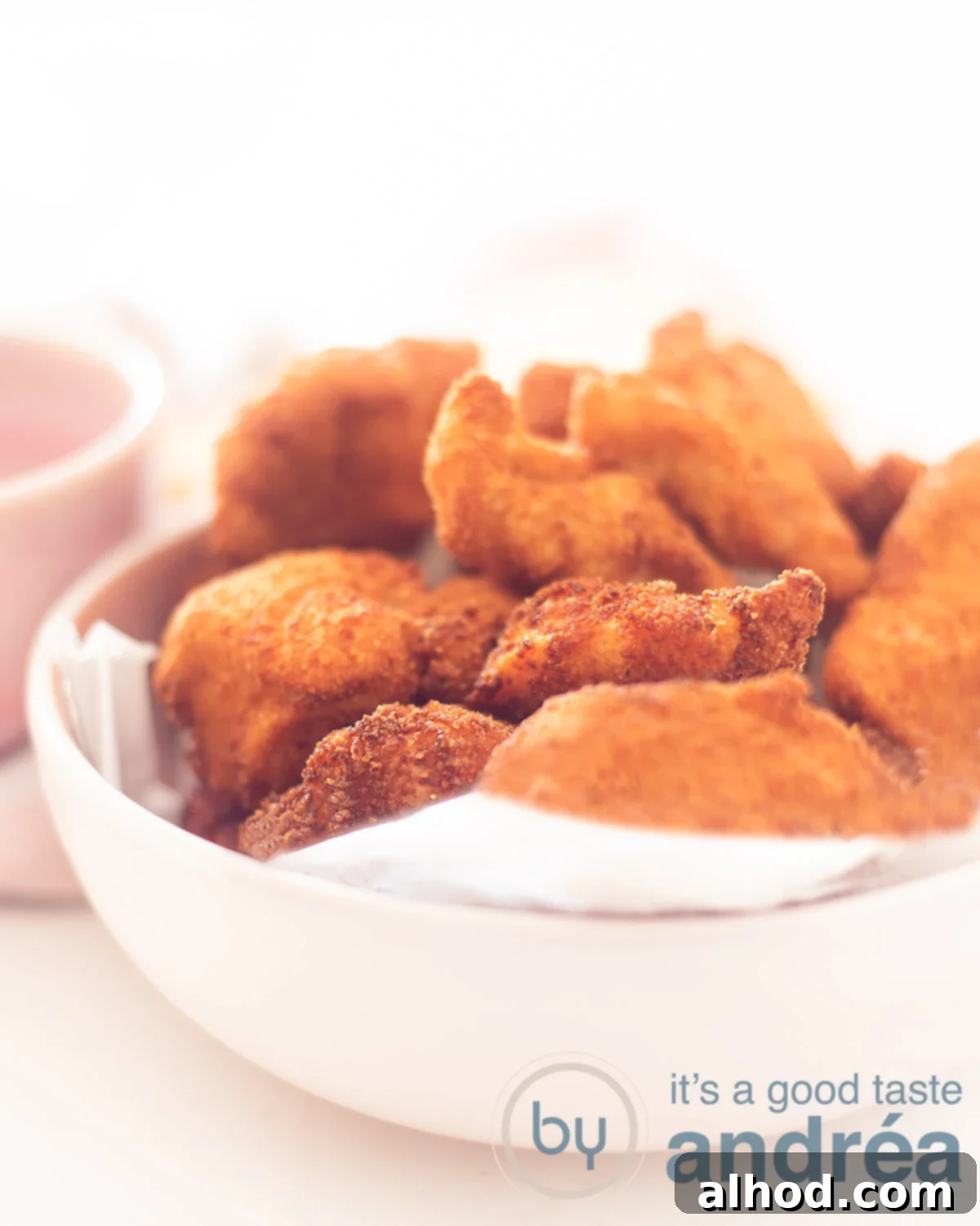 Crispy Parmesan Chicken Bites 5 A close-up shot of crispy chicken nuggets with grated Parmesan cheese, glistening and ready to be served.