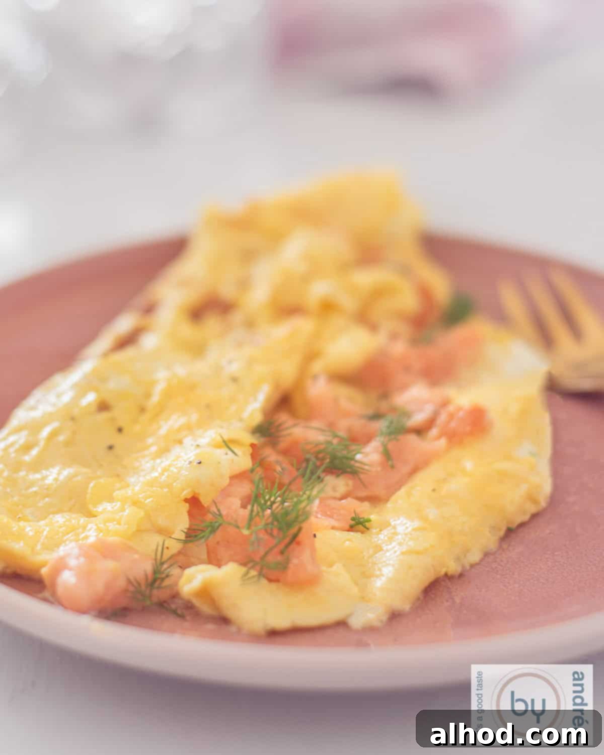Gourmet Smoked Salmon Omelette 2 Omelette with salmon shavings and chives on a pink plate
