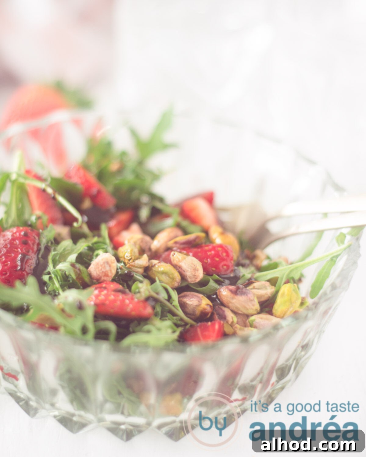Strawberry Pistachio Salad 5 A bowl with Strawberry, arugula and pistachio salad