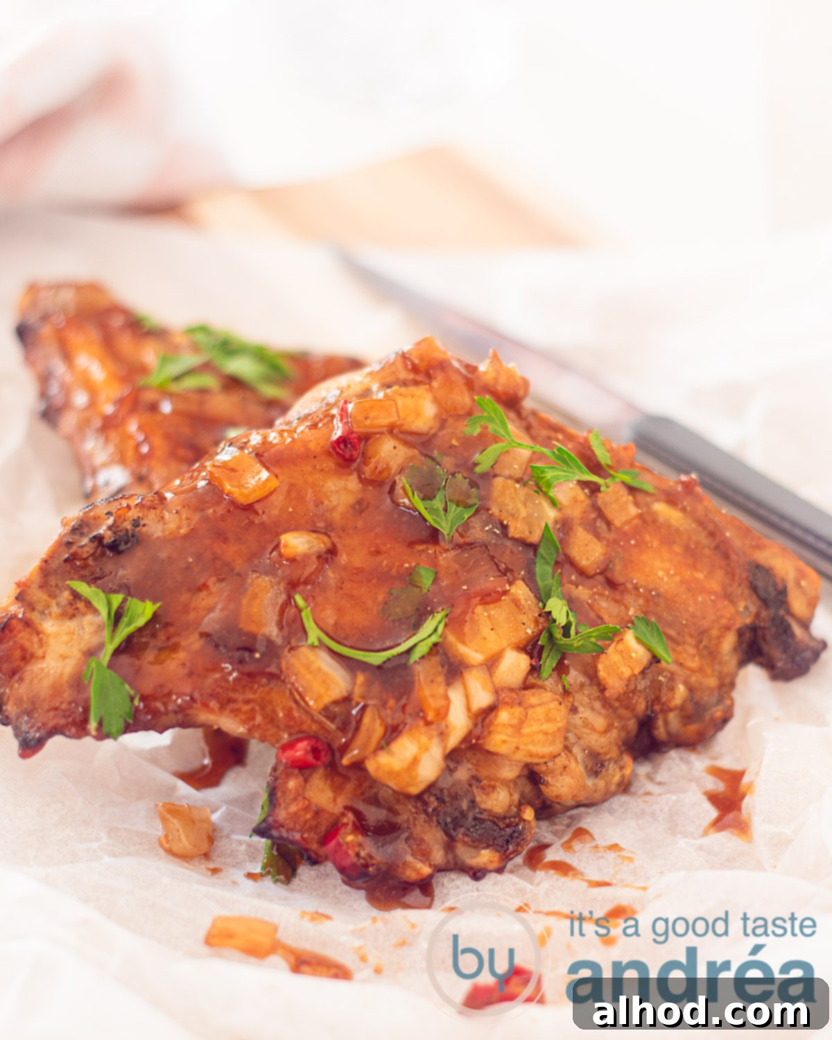 Slow Cooker BBQ Ribs 5 Two pieces of ribs on top of each other covered with BBQ sauce and parsley