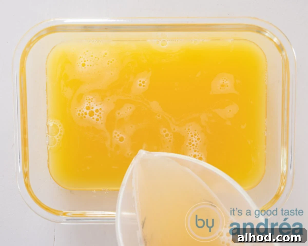 The Hoppy Freeze 4 A measuring cup pours beer into a freezer box with the orange juice