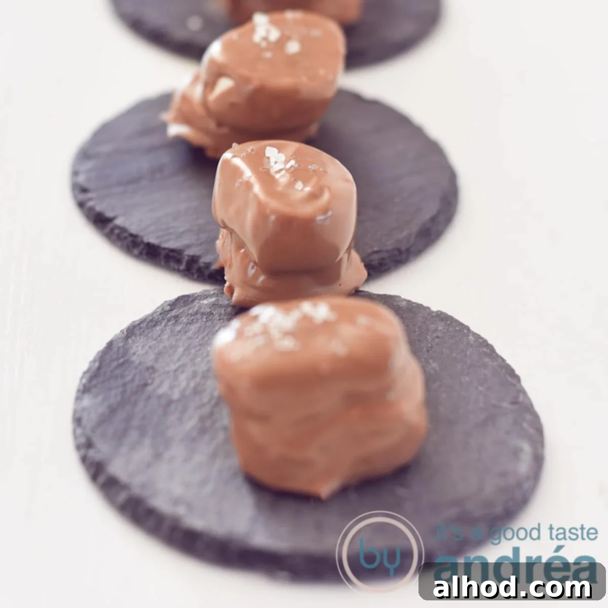 Beer-Spiked Chocolate Marshmallows with Sea Salt 4 A square photo with three chocolate dipped marshmallows with beer on a slate background on a white background