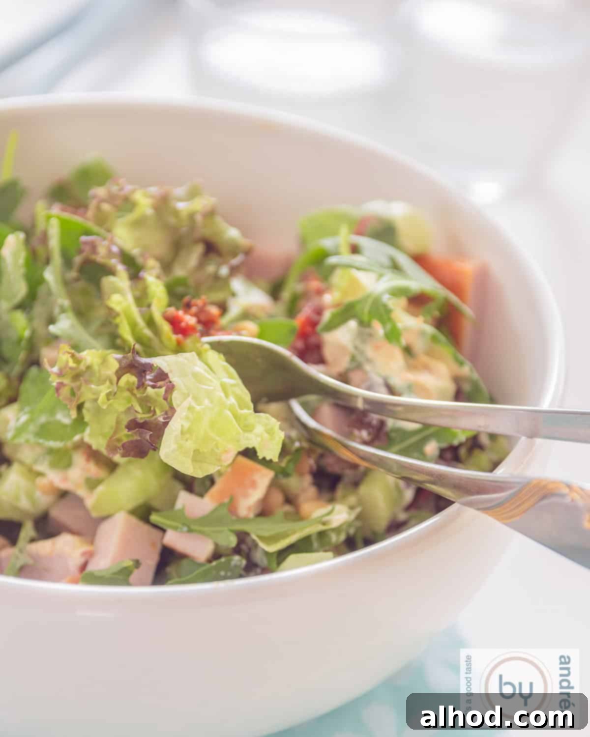 Flavorful Smoked Chicken Salad Made in 10 Minutes 2 A vibrant bowl of green salad featuring tender smoked chicken, rich red pesto, and sweet sun-dried tomatoes, ready to be enjoyed.
