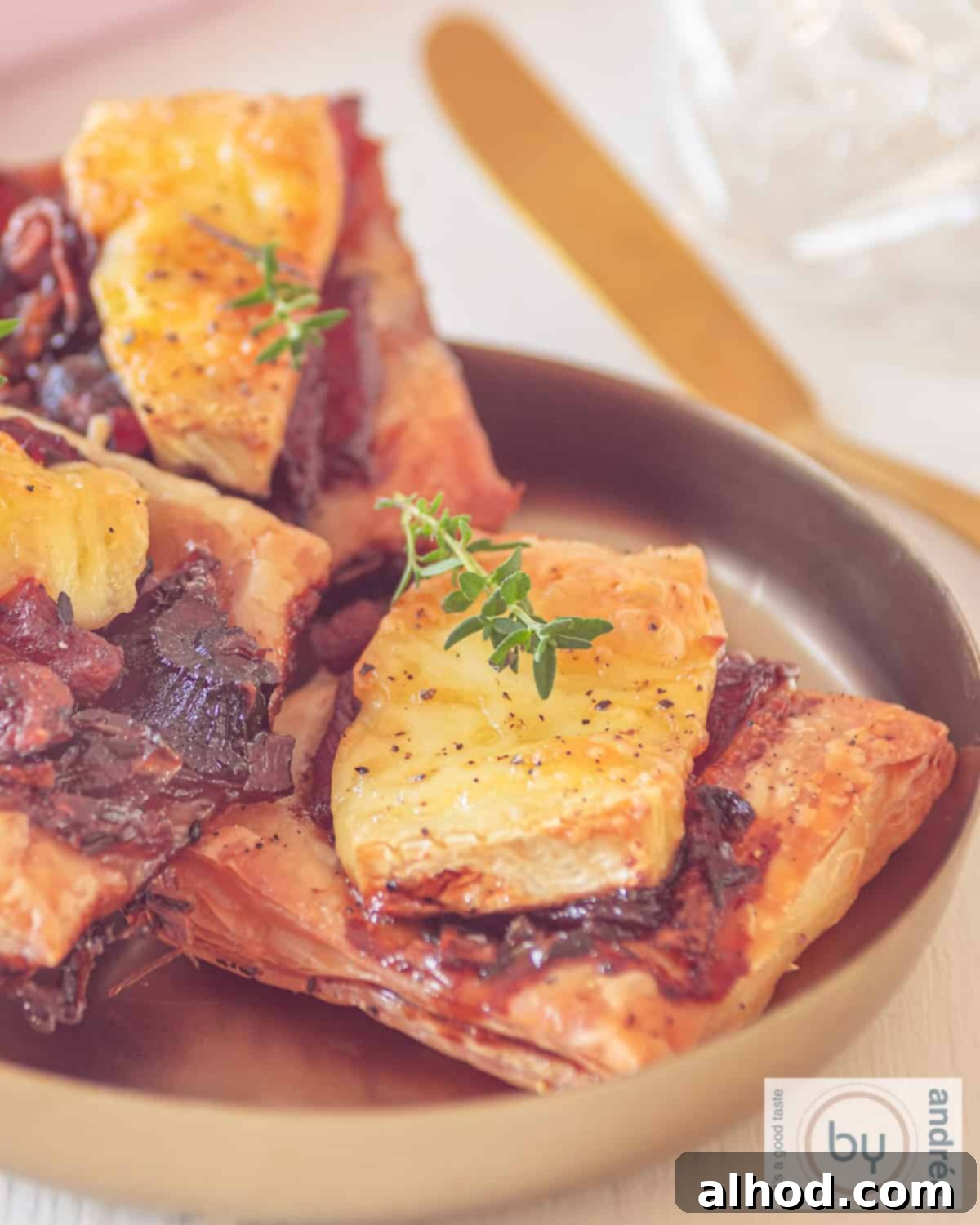 Golden Brie and Caramelized Onion Puffs 2 A portion of a bowl of brie puff pastry snacks with caramelized onion and bacon.