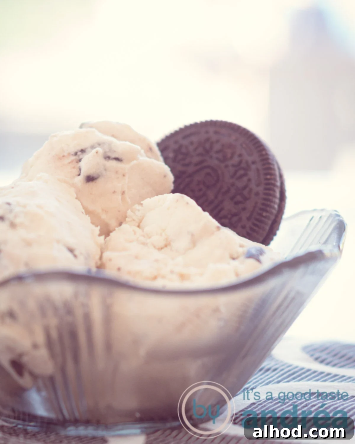 Creamy Egg-Free No-Churn Oreo Gelato 5 A close-up of a black glass bowl filled with three scoops of rich, homemade Oreo ice cream, topped with a crisp Oreo cookie, ready to be enjoyed.