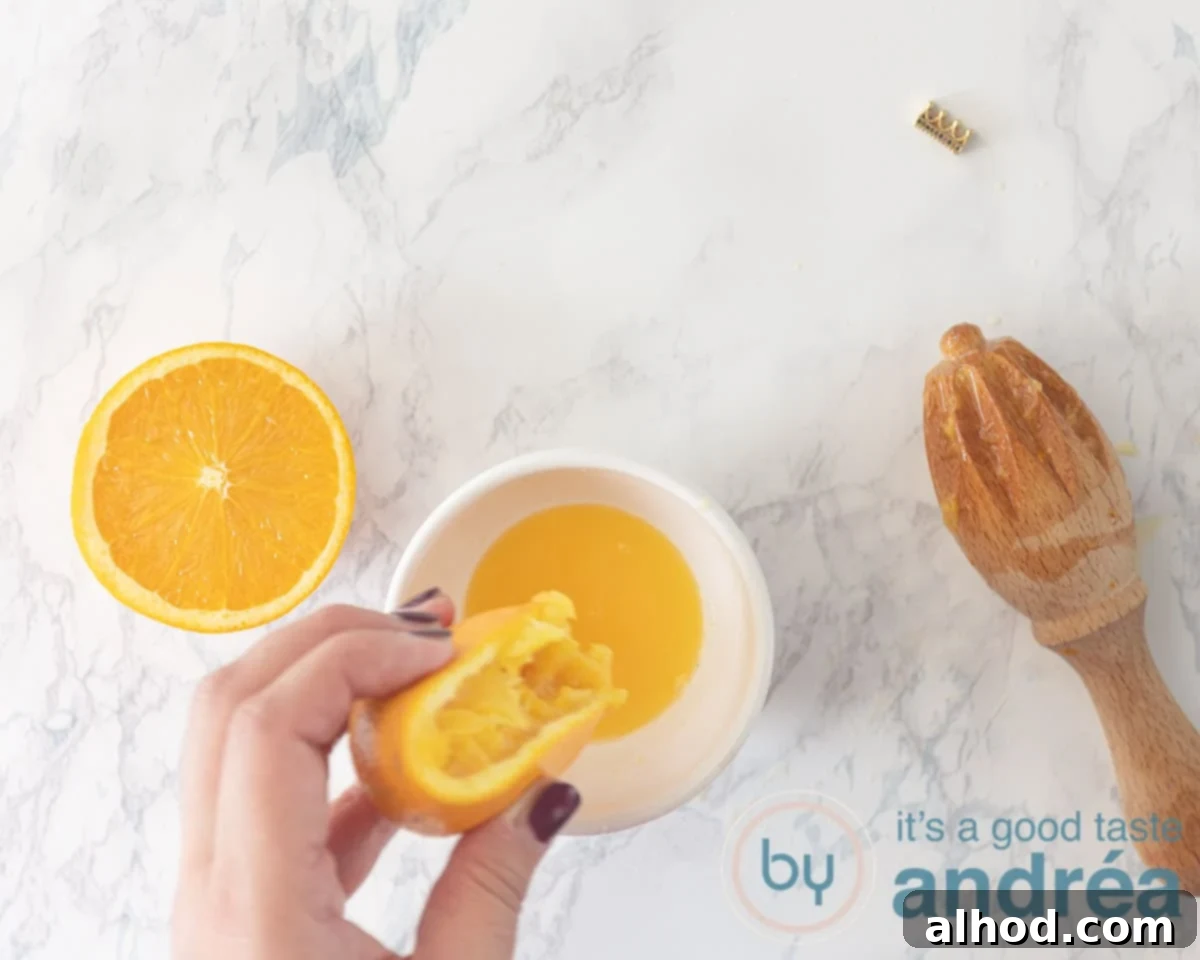 Zesty Berry Orange Blend 4 Hands juicing fresh oranges into a bowl, preparing for the smoothie.