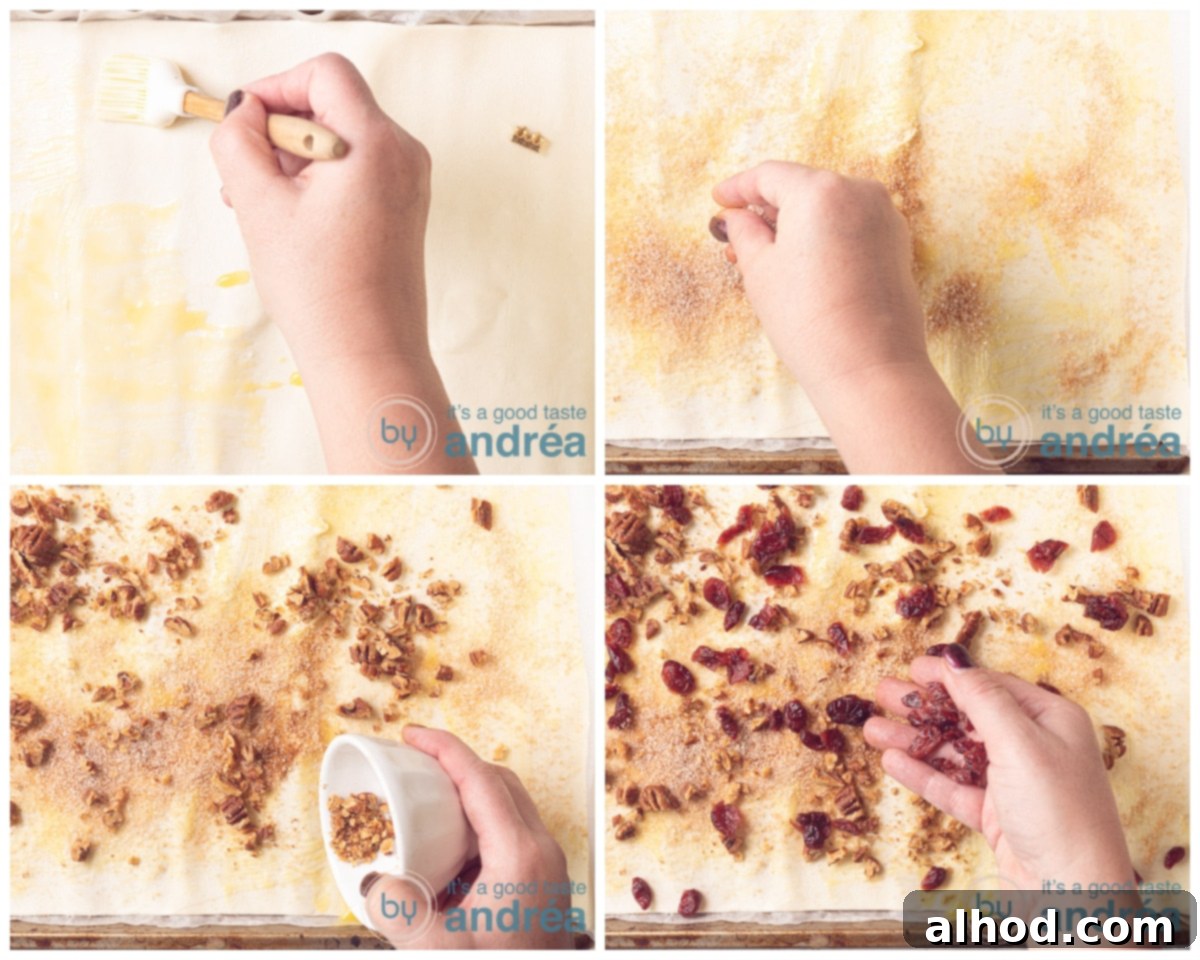 Golden Puff Pastry Cinnamon Buns 4 A sheet of puff pastry brushed with butter, and then evenly sprinkled with cinnamon sugar, chopped pecans, and plump cranberries. This shows the first step of assembling the filling.