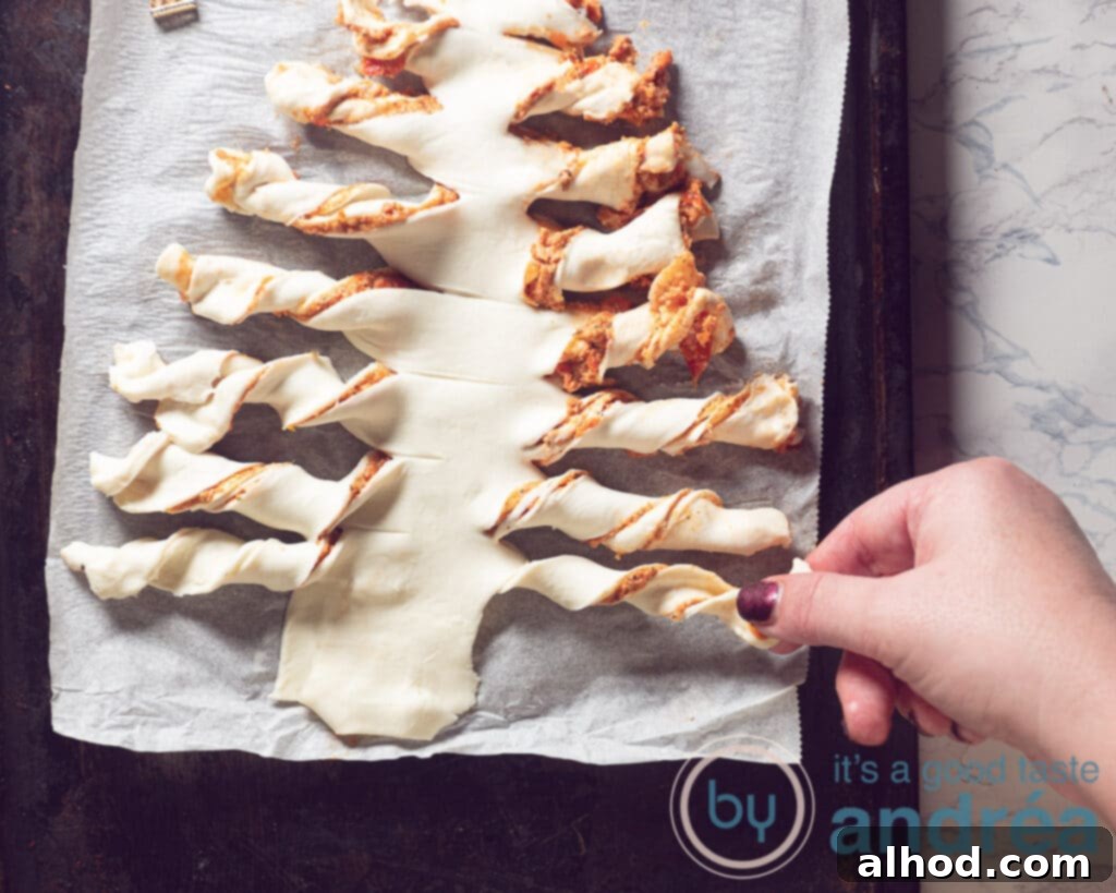 Festive Pesto Puff Pastry Christmas Tree Recipe 7 Twisting the puff pastry branches to create a festive pattern