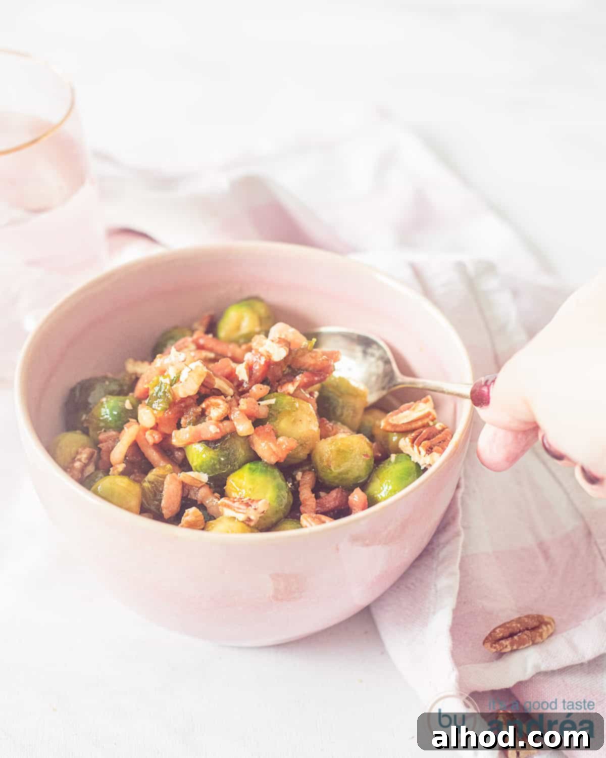 Caramelized Bourbon Brussels and Crispy Bacon 2 Close-up of crispy bourbon-glazed Brussels sprouts with bacon and pecans in a bowl, ready to serve.