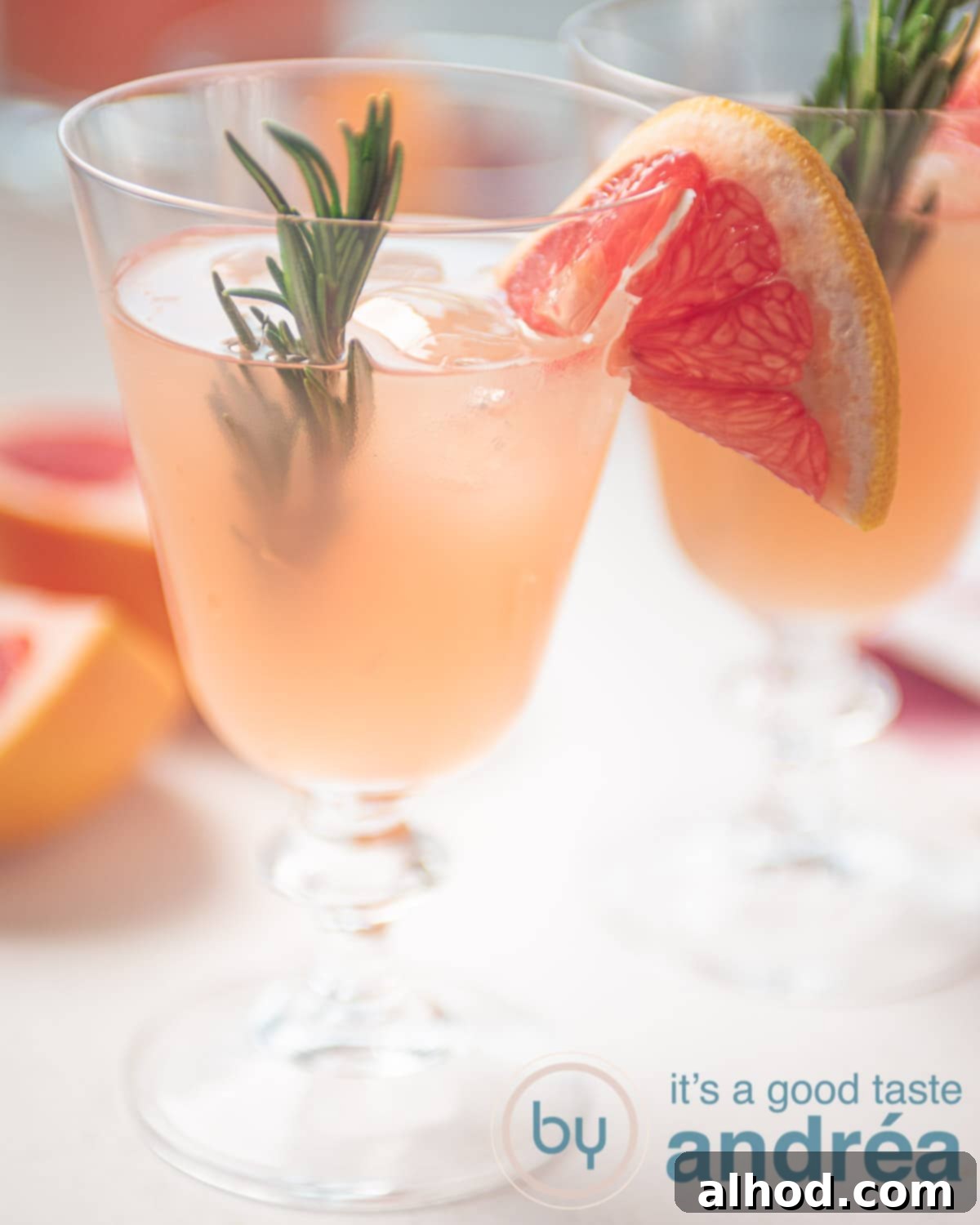 Grapefruit and Rosemary Sparkling Mocktail 9 A glass filled with a rosemary grapefruit mocktail. Garnished with rosemary and slices grapefruit