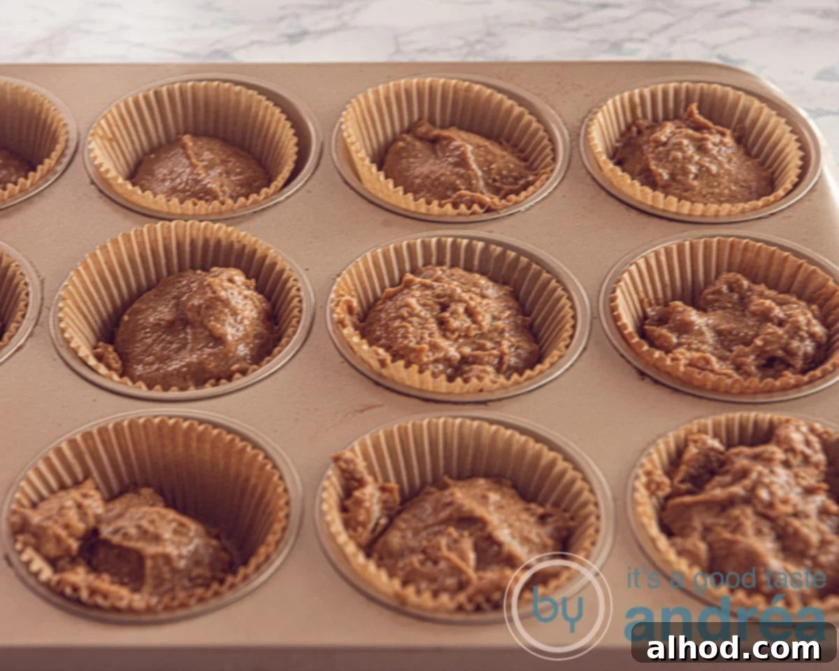 Easy Dutch Stroopwafel Cupcakes 4 Close-up of cupcake batter being spooned into paper liners within a muffin tin.