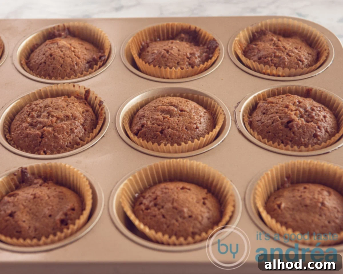 Easy Dutch Stroopwafel Cupcakes 5 A metal muffin tin filled with freshly baked, golden-brown cupcakes cooling after being removed from the oven.