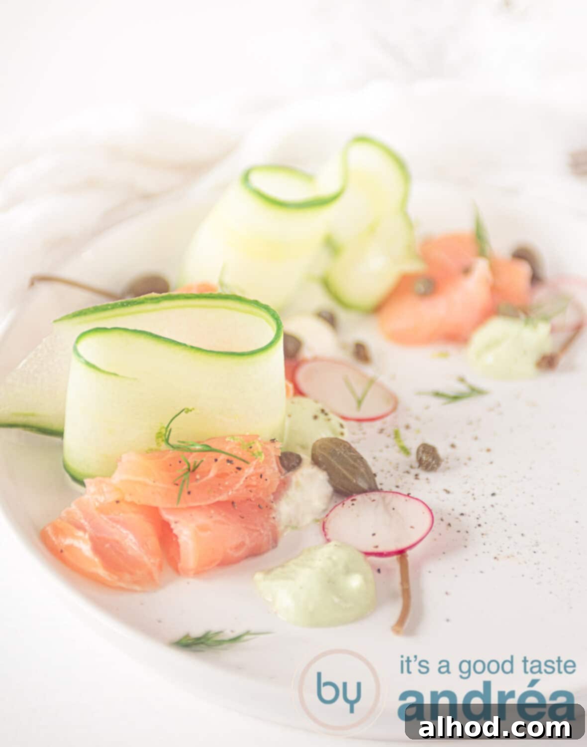 Effortless Smoked Salmon Cucumber Salad 8 A white plate with elegant cucumber ribbons, vodka-marinated smoked salmon, and dollops of horseradish and avocado cream, ready to serve.