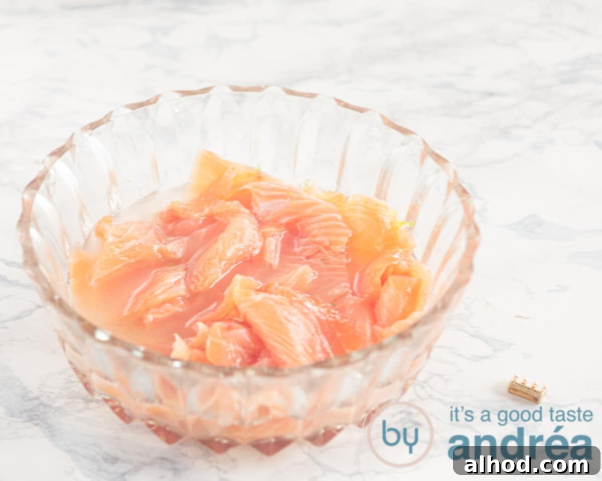 Effortless Smoked Salmon and Cucumber Salad 4 Close-up of thinly sliced smoked salmon marinating in a bowl with vodka and lime juice, ready for the next step in the recipe.