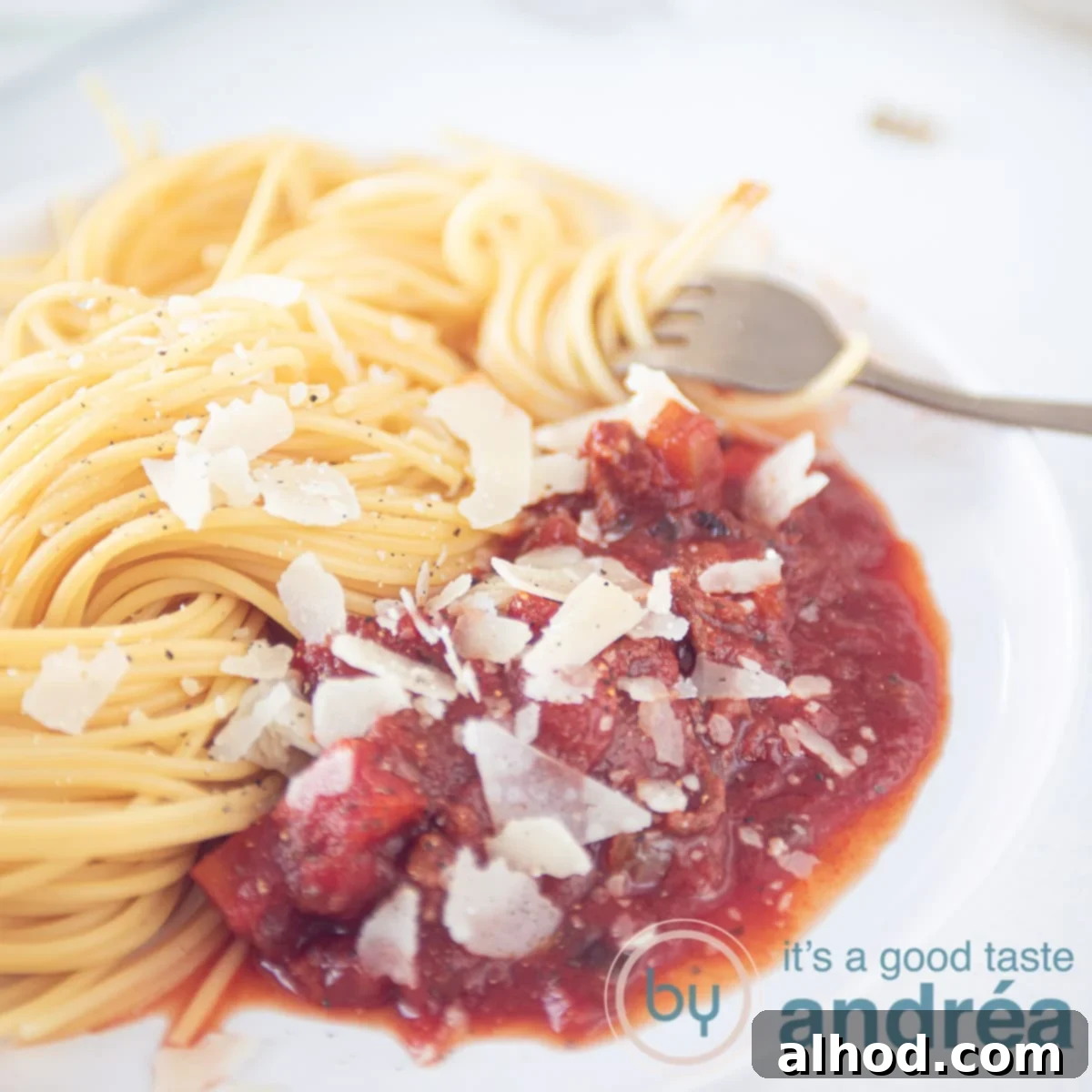 Rich Slow Cooker Beef Spaghetti Sauce 6 square pic slowcooker spaghetti sauce with meat and spaghetti on a white background