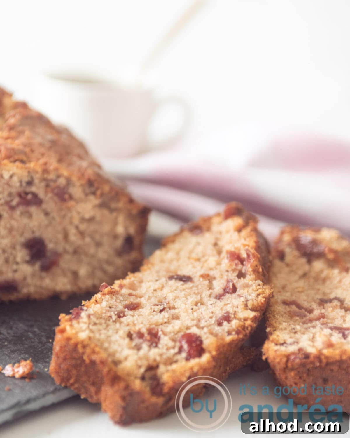 Heavenly Cranberry Walnut Coffee Cake 2 A delicious Cranberry Walnut Coffee Cake on a silver platter, with two slices already cut and ready to serve, showcasing its moist texture and vibrant cranberry and walnut pieces.