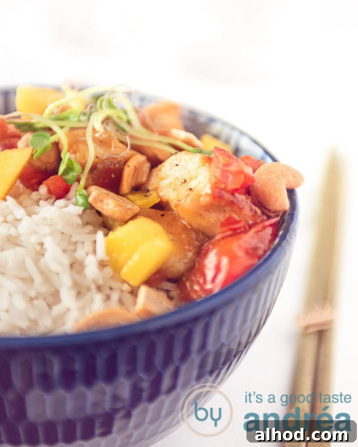 20-Minute Sticky Honey Soy Mango Chicken 3 A close-up of a bowl filled with fluffy white rice, ready to be topped with delicious honey chicken, mango, and cashews.
