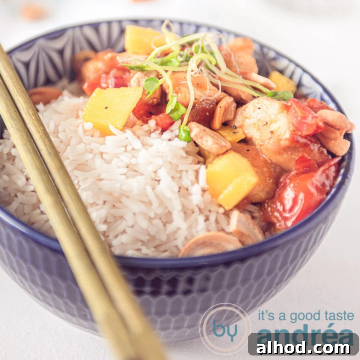 20-Minute Sticky Honey Soy Mango Chicken 4 A small blue bowl with rice, honey chicken, mango and tomato